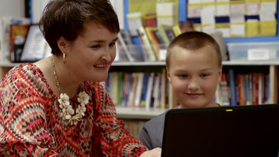 Brandee Green, 4th and 5th Grade ELA, Social Studies Teacher and Department Chair at Aiken Elementary School works with a student using OneNote on a Windows device