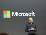 Satya Nadella onstage with Microsoft logo