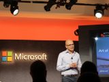 Satya Nadella onstage with Microsoft logo