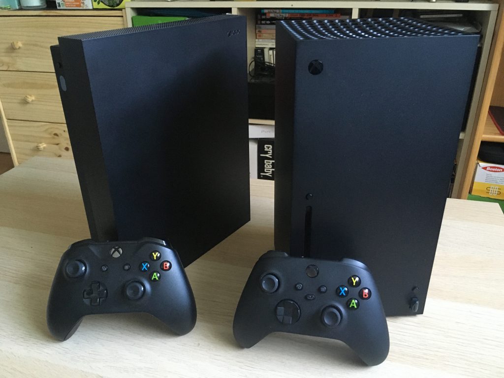Xbox One X Xbox Series X In Vertical Position With Controllers