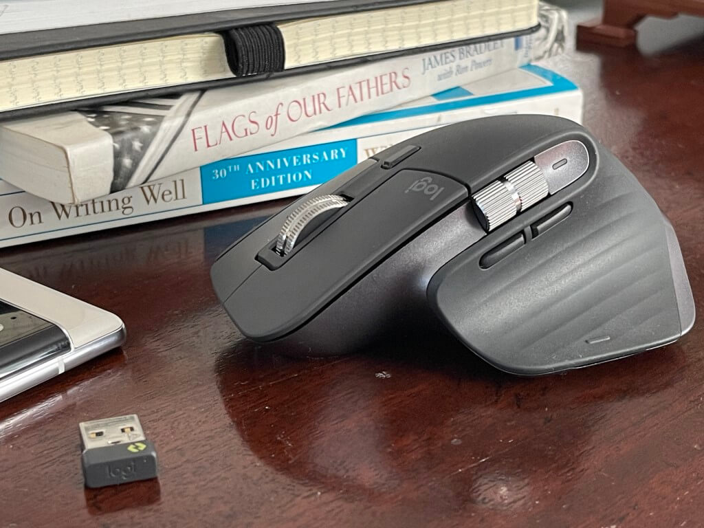 The MX Master 3s Mouse sitting next to books.